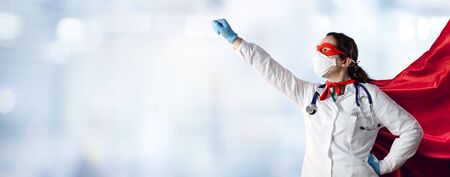Doctor In Face Mask And Superhero Cape In Hospitalの写真素材