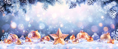 Abstract Christmas Card - Golden Ornament On snow With Fir Branches And Defocused Lightsの写真素材