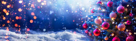 Abstract Snowy Christmas Tree On Snow With Snowfall And Defocused Lights In The Nightの写真素材