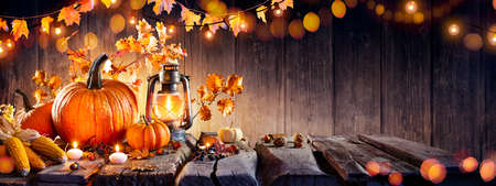 Thanksgiving - Old Table With Pumpkins And Corns With Bokeh Lights In Dark Backgroundの写真素材