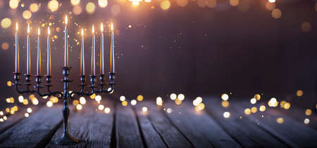 Hanukkah Abstract Defocused Background - Menorah With Bright Dust On Wooden Tableの写真素材