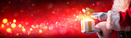 Santa Claus Opening Christmas Present With Shiny Starsの写真素材