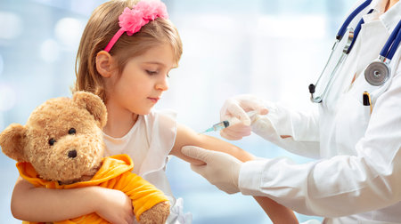 Vaccination Concept - Female Doctor Vaccinating Cute Little Girl On Blue Backgroundの写真素材