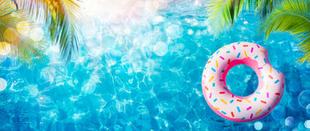 Inflatable Donut In Pool With Palm Leaves And Sunlightの写真素材