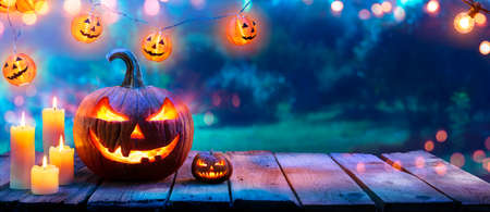 Pumpkin With Candles On Table In Garden - Halloween In Outdoorの写真素材