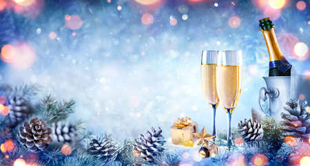 Christmas Celebration With Champagne - Flutes On Snow With Fir Branch And Bokehの写真素材