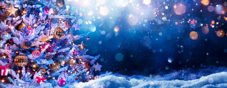 Christmas Tree On Snow At Night - Ornament hanging With Defocused Lights In Abstract Backgroundの写真素材