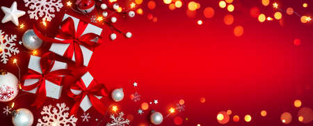 Gift Boxes On Red With Christmas Ornaments - Presents With Bokeh Lights And Snowflakesの写真素材