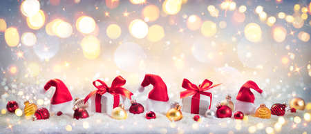 Christmas Gift And Ornament On Snow With Golden Shiny Lights - Abstract Defocused Background With Vintage Colorsの写真素材