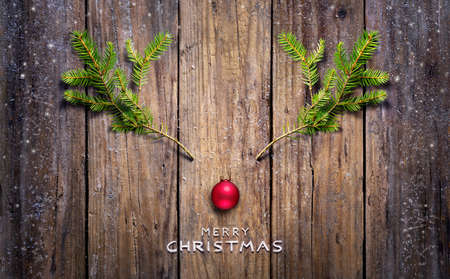 Christmas Concept - Reindeer Made With Fir Branches And Red Ball On Wooden Plankの写真素材