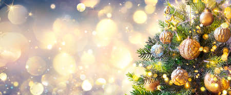 Christmas Tree In Golden Sparkle Background - Shiny Balls With Vintage Defocused Abstract Lightsの写真素材