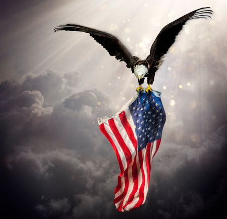 Eagle With American Flag Flies In The Sky With Blurred Bokeh And Sunlight Effect - Independence Dayの写真素材