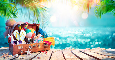 Travel Suitcase On Tropical Beach With Sunny Sea And Palm Leaves - Defocused Abstract Backgroundの写真素材