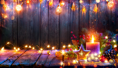 Advent - Candle Glowing In Christmas Lights On Wooden Table With Decoration - Defocused Bokeh And Glittering Effect On Backgroundの写真素材