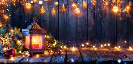 Christmas Lantern Glowing On Wooden Table With Decoration And String Lights - Bokeh And Glittering Effect On Backgroundの写真素材
