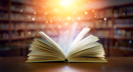 Book With Magic Lights And Bright Letters In Defocused Modern Libraryの写真素材