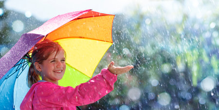 Happy Child With Umbrella Under Rain - Joy And Laughing With Autumn Showerの写真素材