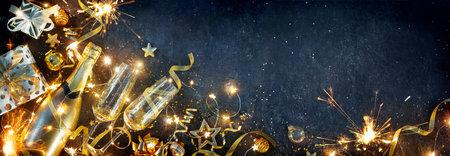 New Year Celebration - Champagne Flutes And Gift Boxes With Golden Decoration And Sparkler On Shiny Backgroundの写真素材