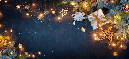 Christmas Lights With Gift Boxes Ornaments And Fir Branches On Blue Backgroundの写真素材