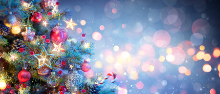 Christmas Tree With Ornaments In Blue - Baubles Hanging On Fir Branches With Glittering And Bokeh Lights In Abstract Defocused Backgroundの写真素材