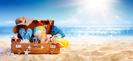 Summer Beach Preparation - Suitcase And Accessories With Sand And Defocused Glittering On Sea - Travel and Departure Conceptsの写真素材