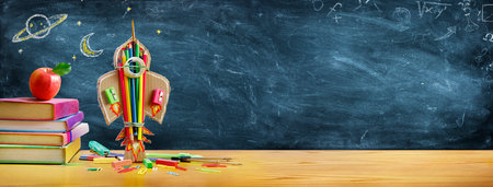 Start School Concept - Rocket And Stationery On Desk With Drawn On Blackboardの写真素材