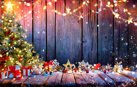 Christmas Tree With Gift Boxes On Rustic Wooden Table With Garland And Decorations - Abstract Defocused Lightsの写真素材