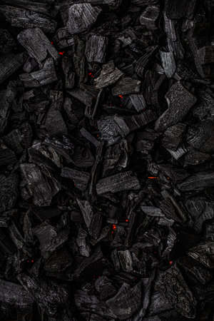 Charcoal with red streaks of heat. Textured dark background.の写真素材