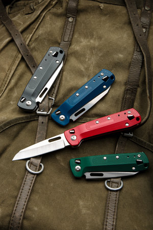 Folding multitool penknives on a khaki canvas backpack. A pocket-sized tool for hiking and daily life.の写真素材