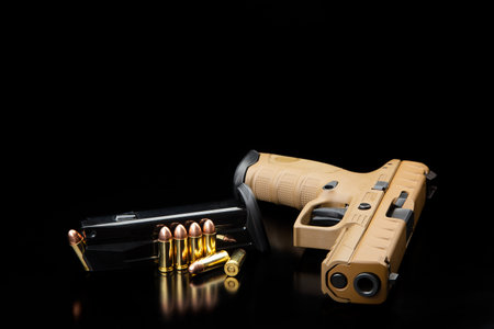 Brown modern gun and ammunition for it on adark background. Short-barreled weapons for sports and...
