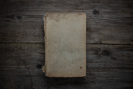 Closed book on vintage wooden background. Old book on the wooden table. Closed book with empty cover laying on wooden table.の写真素材