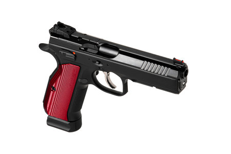 A modern black semi-automatic pistol with a red grip. A short-barreled weapon for self-defense and sport. Isolate on a white background.の写真素材