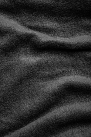 Texture of warm woolen fabric with folds. Gray wavy felt background.の写真素材