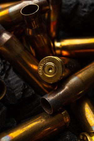 Empty shells from weapons on black smoldering coals. Consequences of the war. dark background.の写真素材