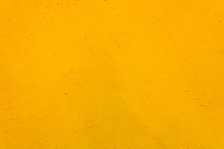 The metal surface is rough, with smudges, painted with yellow paint. Bright colored background.の写真素材