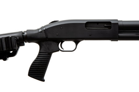Pump-action 12 gauge shotgun isolated on a white background. Close-up shot of part of a shotgun. A smooth-bore weapon with a plastic stock.の写真素材
