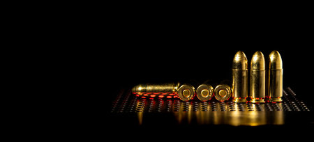 Pistol cartridges 9 mm on a smooth glossy surface with reflections. Ammunition for pistols and PCC...