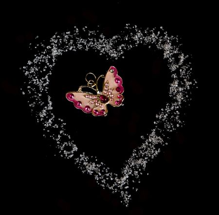 butterfly in heart from sugar in black backgroundの写真素材