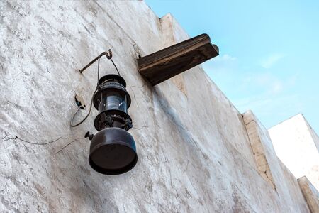 Vintage kerosene lamp on the white wall of a dilapidated buildingの写真素材