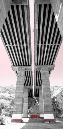Red bus in the wadi under the highway bridge. Dichromaticの写真素材