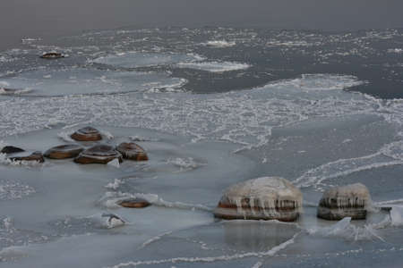 Stones and Ice Patterns and Craters in Snow on Seasideの写真素材