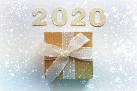 2020. Christmas background, Christmas composition. Gift box with ribbon,bokeh, white snowflakes,...