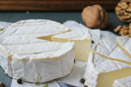 Camembert cheese. Farm products, cottage cheese. round head cheese with mold, sliced on a wooden...