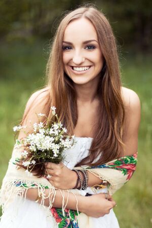 Summer girl portrait. Young woman smiling happy on sunny summer or spring day outside in park の写真素材