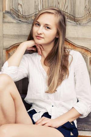 Portrait of beautiful blond woman leaning against home wall の写真素材