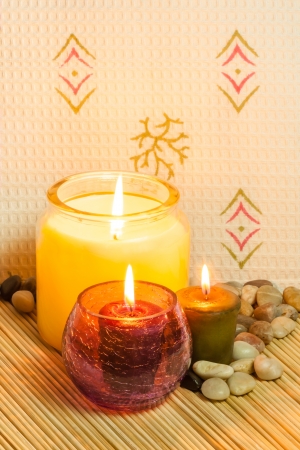 An image of candles set on a bed of bamboo, used in aromatherapy in a spa.の写真素材