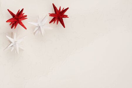 Christmas star ornaments background - An elegant Christmas background with red and white stars on a faded floral off white tile.の写真素材
