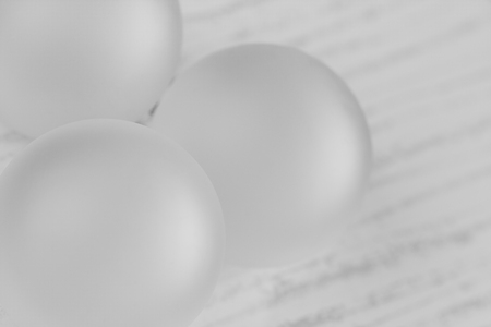 White Christmas ornaments background - A plain white monochrome Christmas background on a striped tile. Shallow Depth of field used.の写真素材