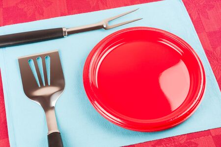 Barbecue Time - A set of barbecue tools and plastic plate on a blue cloth mat symbolizing barbecue time.の写真素材