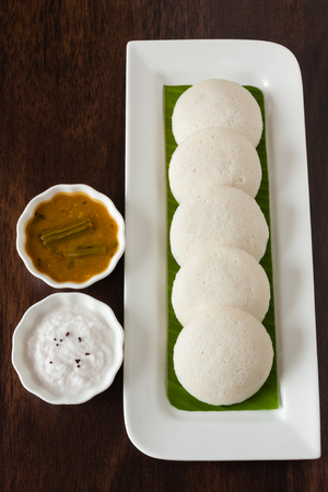 Indian idly with chutney and sambar - Fresh steamed Indian Idly (Idli / rice cake) arranged on...